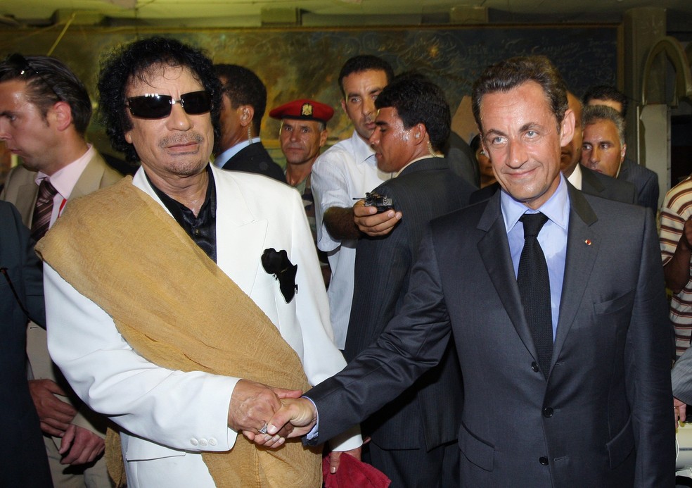 Ditador da Líbia, Muammar Kadafi (E), aperta a mão do presidente da França, Nicolas Sarkozy, durante encontro em Tripoli — Foto: PATRICK KOVARIK/AFP