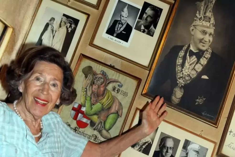 Inge ao lado de uma foto de seu pai, que fundou a vinícola em 1955 — Foto: Reinhard Roskaritz - Cortesia/ Bild