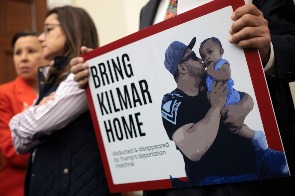 Membro da bancada hispânica da Câmara dos Deputados dos EUA com cartaz pedindo o retorno de Kilmar Armando Abrego Garcia, deportado por engano para El Salvador — Foto: ALEX WONG / GETTY IMAGES NORTH AMERICA / AFP