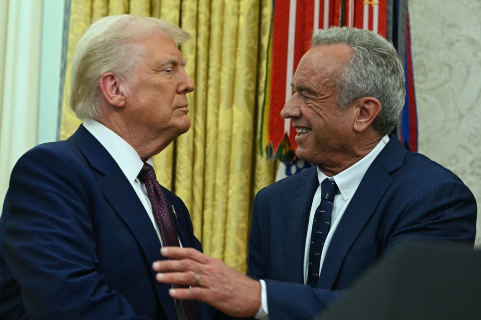 Robert Kennedy Jr. aperta a mão de Donald Trump após cerimônia de juramento no Salão Oval da Casa Branca, em Washington — Foto: ANDREW CABALLERO-REYNOLDS / AFP