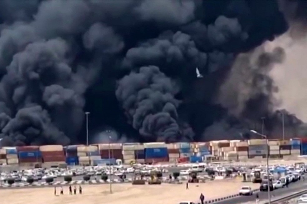 Densa fumaça preta subindo após uma explosão no cais do porto de Shahid Rajaee — Foto: IRIBNEWS / AFP
