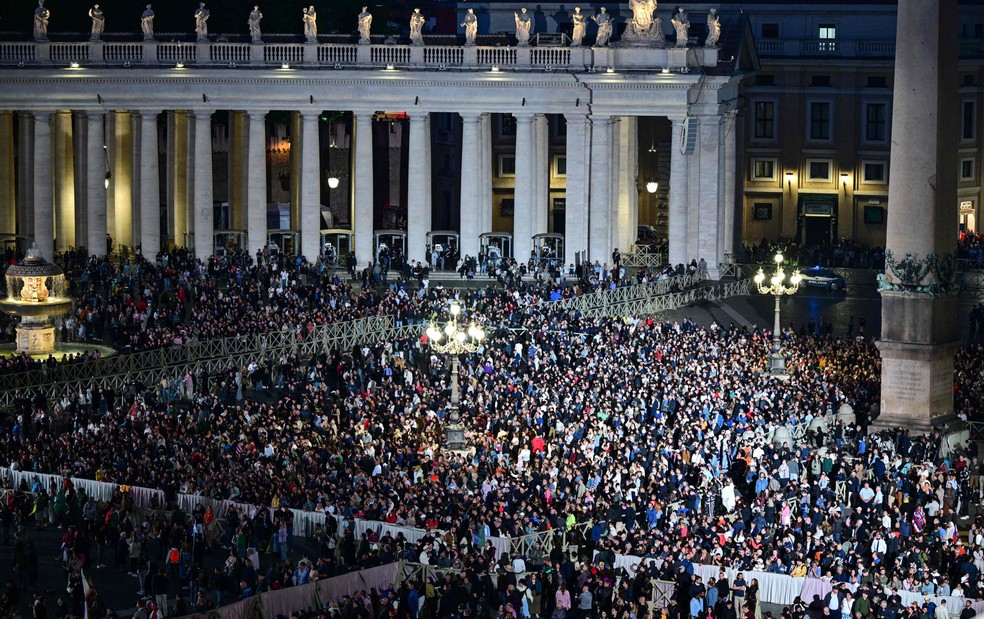 A Praça de São Pedro ficou lotada até o anoitecer, quando a fumaça preta apareceu na chaminé — Foto: Andrej ISAKOVIC / AFP