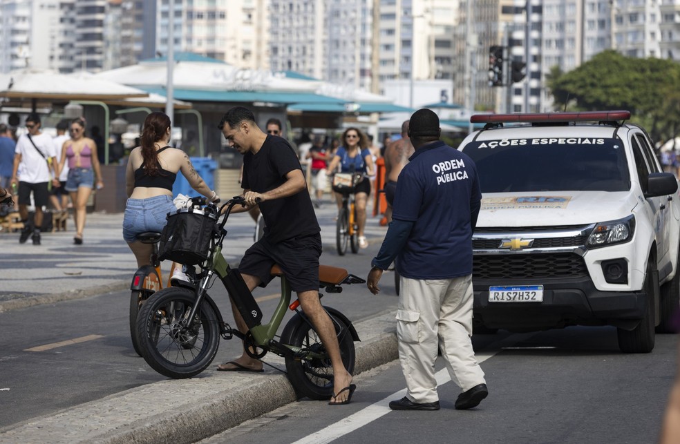 Na foto, agentes da Seop orientam ciclistas na pista fechada para lazer da Avenida Atlântica — Foto: Márcia Foletto