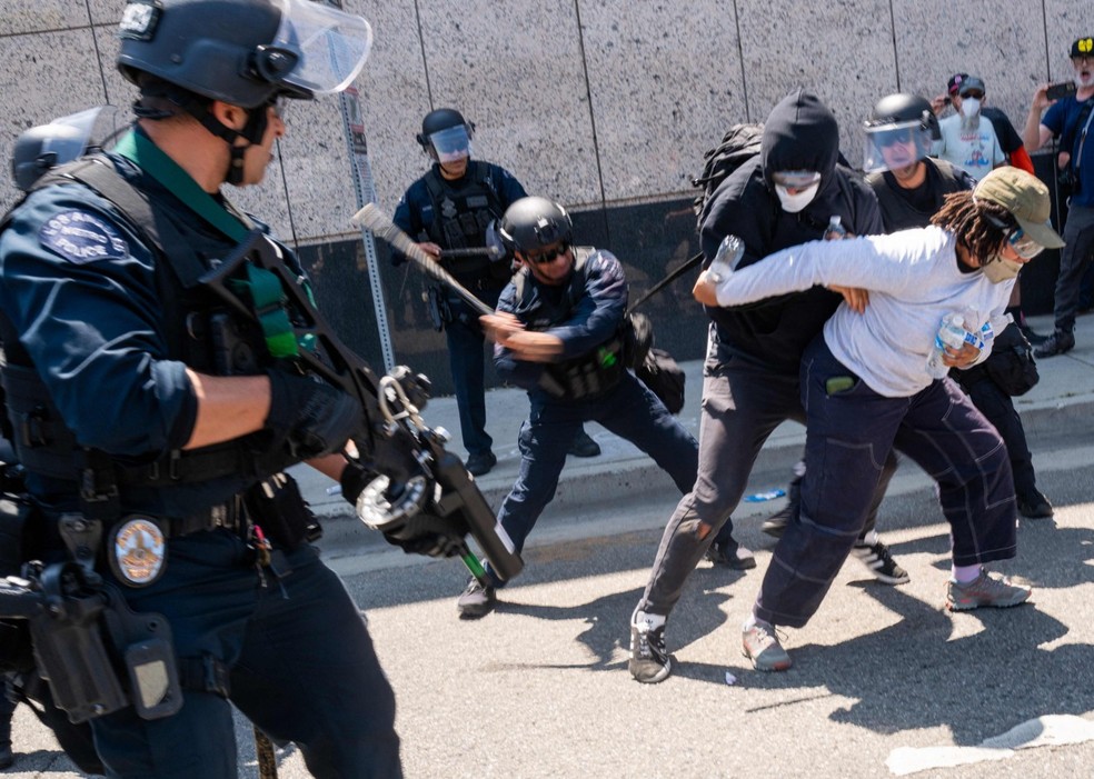 Manifestante é detido por agentes durante protesto pró-imigração em Los Angeles — Foto: AFP