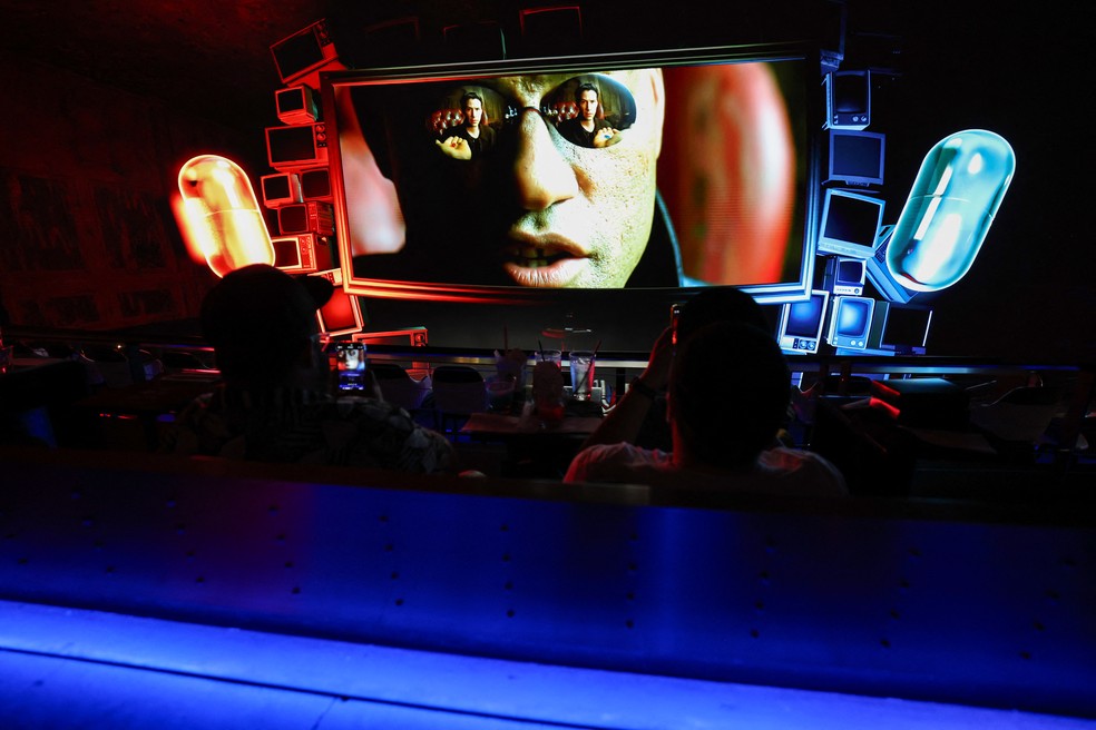 O personagem Morpheus aparece na tela com uma exibição estendida da pílula vermelha e da pílula azul — Foto: Patrick T. Fallon / AFP
