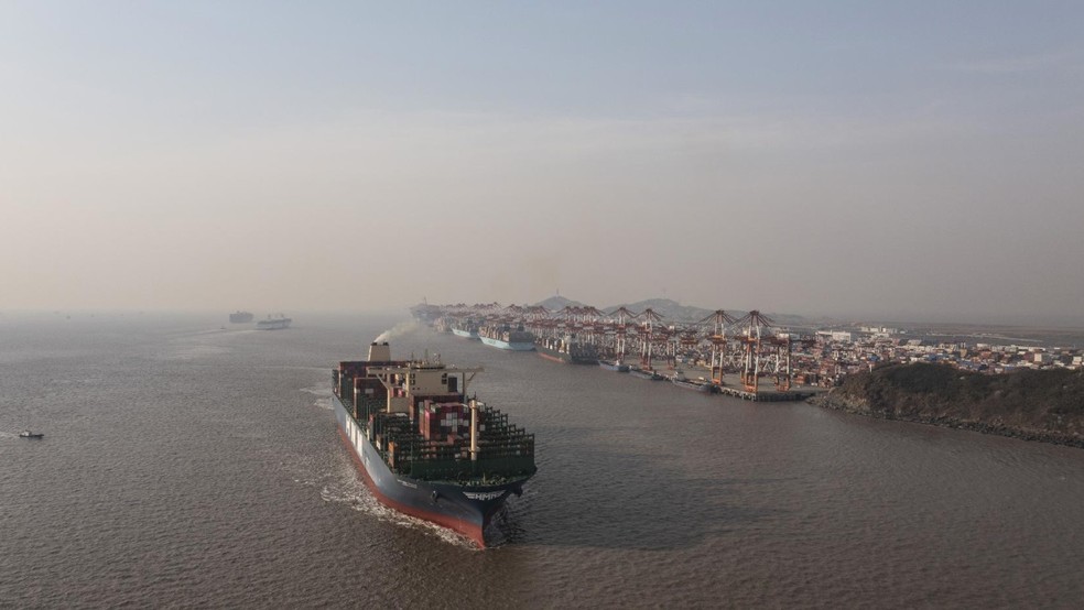 Navio de carga no Porto de Yangshan, em Xangai: as economias dos EUA e da China continuam profundamente integradas, com centenas de bilhões de dólares em comércio cruzando o Pacífico a cada ano — Foto: The New York Times