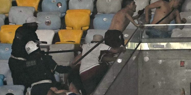 Torcedores do Lanús e policiais entram em confronto em jogo contra Fluminense — Foto: Mauro Pimentel/AFP