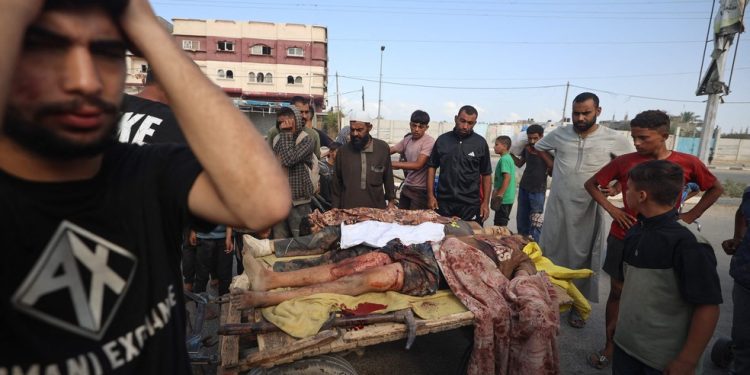 Palestinos reagem ao lado dos corpos de pessoas que teriam sido mortas enquanto se reuniam para coletar ajuda humanitária em um centro de distribuição administrado pela Fundação Humanitária de Gaza — Foto: Eyad Baba/AFP