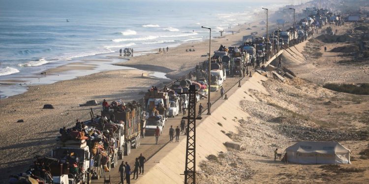 Palestinos deslocados seguem com seus pertences para o sul em uma estrada na área do campo de refugiados de Nuseirat, no centro da Faixa de Gaza — Foto: Eyad Baba/AFP