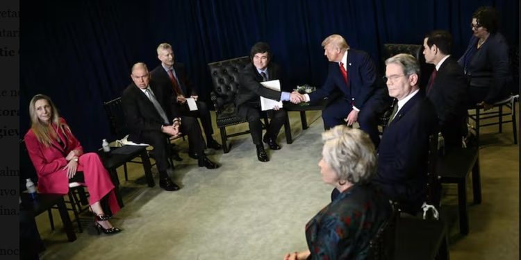 Milei e Trump se cumprimentam cercado por funcionários do governo do dois países, entre eles o secretário do Tesouro dos EUA, Scott Bessent — Foto: Brendan Smialowski/AFP