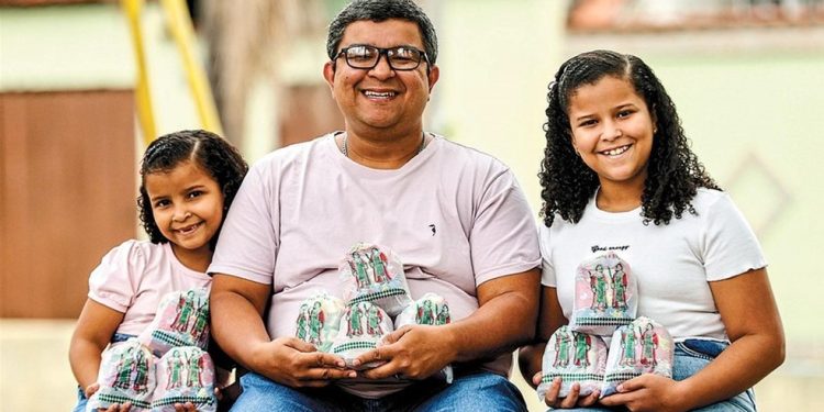 Devoção no nome. Nascido em 27 de setembro, Cosme Damião Silveira vai distribuir saquinhos de doce com as filhas Beatriz e Alice: promessa feita depois que a caçula se curou de uma pneumonia — Foto: Gabriel de Paiva