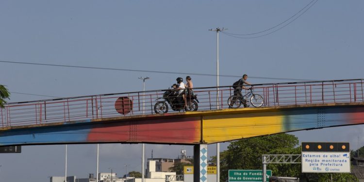 Lei ignorada. Motociclistas usam passarela de pedestres na Avenida Brasil — Foto: Domingos Peixoto