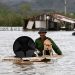 Um agricultor resgata seu cachorro e alguns pertences de sua casa inundada após a passagem do furacão Melissa pela cidade de San Miguel de Parada, na província de Santiago de Cuba, em 29 de outubro de 2025 — Foto: Yamil Lage / AFP