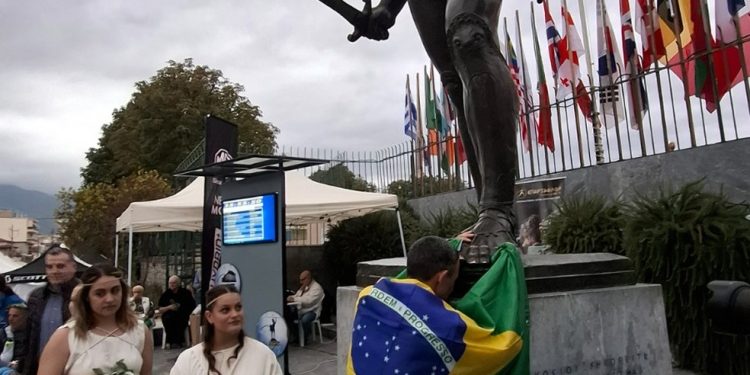 Cristiano Marcelino, após cruzar a linha de chegada, aos pés da estátua do Rei Leônidas de Esparta — Foto: Divulgação / Sparta Photography Club