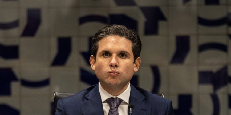 Hugo Motta sentado em cima do projeto que pune o devedor contumaz