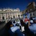 Fiel segura retrato do adolescente Carlo Acutis em frente à Basílica de São Pedro, antes da Santa Missa e da cerimônia de canonização do beato — Foto: Filippo Monteforte / AFP