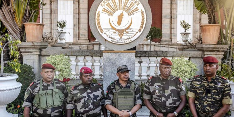 Coronel Michael Randrianirina (ao centro), chefe da unidade militar CAPSAT, está com outros membros da unidade após ler uma declaração em frente ao palácio presidencial, onde anunciou que estão tomando o poder em Antananarivo — Foto: Luis Tato/AFP