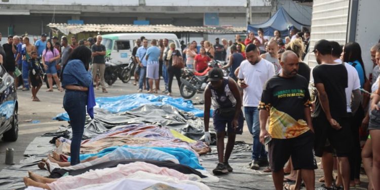 Moradores levam 40 corpos para praça do Complexo da Penha. Rio — Foto: Fabiano Rocha