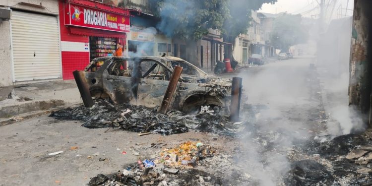 Carro é incendiado e usado como barricada durante operação no Complexo do Alemão — Foto: Fabiano Rocha / Agência O Globo