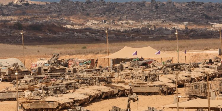 Soldados israelenses realizam manutenção em seus veículos blindados em uma posição ao longo da cerca da fronteira entre Israel e Gaza — Foto: Jack Guez/AFP