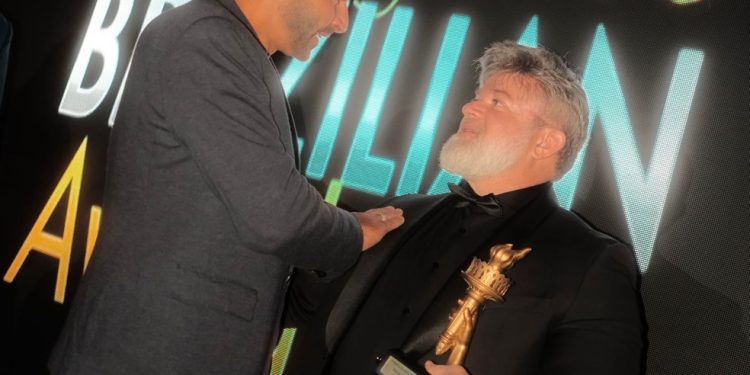 Douglas Fonseca participou de uma premiação em Nova York e recebeu o troféu das mãos de Henri Castelli — Foto: Divulgação