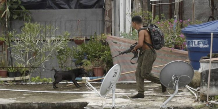 Traficante flagrado armado com fuzil corre sobre telhados durante operação do Bope no Morro da Babilônia, na Zona Sul, em 2018 — Foto: Marcelo Carnaval / Agência O Globo