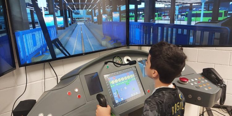 Athos, de 8 anos, com o simulador de condução do VLT, supercomputador que simula operação — Foto: Divulgação