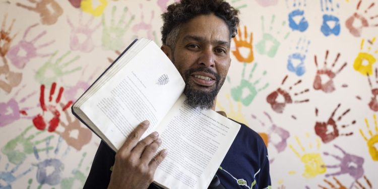 Heitor Leonardo Silva, 41 anos, veio de Belo Horizonte para o Rio e fica em abrigos. O livro é o companheiro — Foto: Márcia Foletto