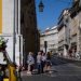Pedestres e tuk tuk de turismo aguardam para atravessar rua em Lisboa — Foto: Patrícia de Melo Moreira/AFP