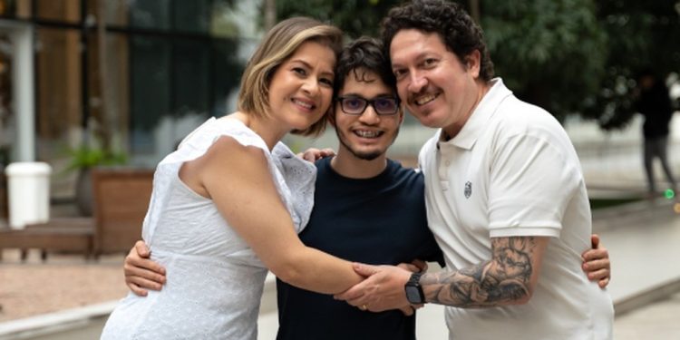 Arthur, hoje aos 19 anos, abraçado por seus seus pais, Ana Paula e Paulo — Foto: Divulgação/Perinatal