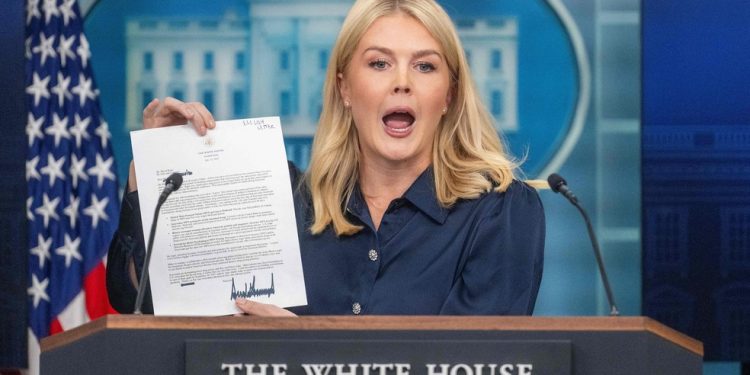 A porta-voz da Casa Branca, Karoline Leavitt, mostra uma carta endereçada à empresa farmacêutica americana Eli Lilly pelo presidente Trump durante a coletiva diária — Foto: Jim Watson/AFP