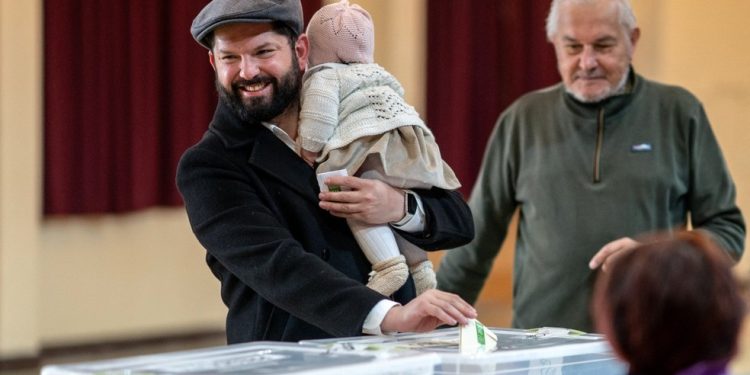 O presidente chileno Gabriel Boric com sua filha Violeta votando nas eleições gerais em Punta Arenas, província de Magalhães, Chile, em 16 de novembro de 2025 — Foto: MARCELO SEGURA / AFP