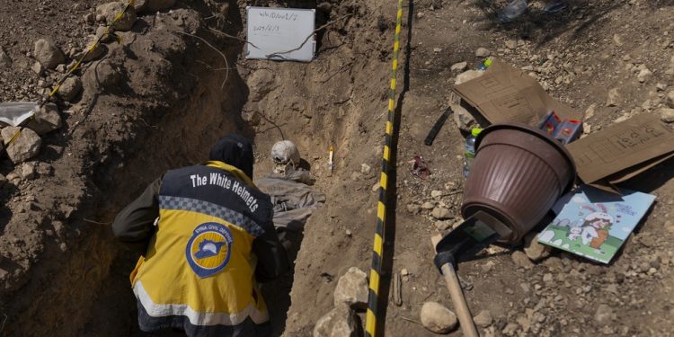 Eman Zaaroor, de 26 anos, da cidade de Aleppo, no norte da Síria, escava uma sepultura simulada como parte de seu treinamento em Damasco — Foto: Diego Ibarra Sánchez/The New York Times