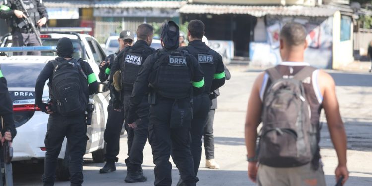 Policiais ( com coletes) durante operação na Vila Kennedy — Foto: Fabiano Rocha / Agência O Globo
