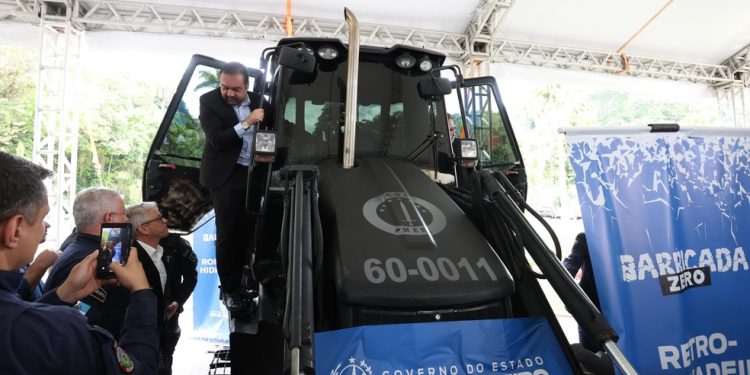 O governador Claudio Castro sobe em retroescavadeira que será usada na retirada de barricadas — Foto: Gabriel de Paiva / Agência O Globo