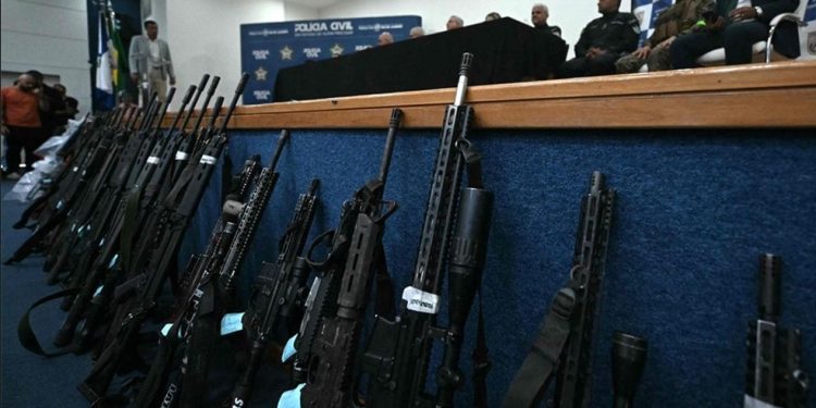 Poderio bélico. Policiais civis e militares apreenderam 118 armas, sendo 91 fuzis, nos complexos do Alemão e da Penha, dominados pelo Comando Vermelho — Foto: Mauro Pimentel/AFP