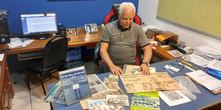 Justiniano Conhasca exibe revistas antigas que registram sua passagem pelo futebol profissional antes de abrir o escritório no “Shopping das Galinhas” — Foto: Felipe Gelani