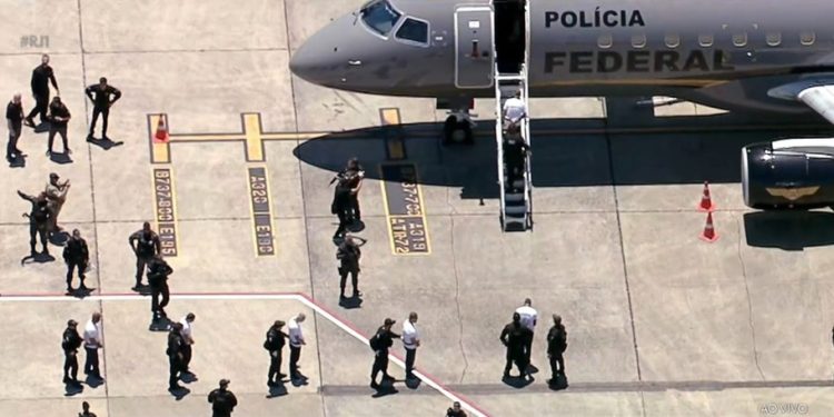 Presos a caminho do avião, no Aeroporto do Galeão, para transferência a presídios federais — Foto: Reprodução / TV Globo