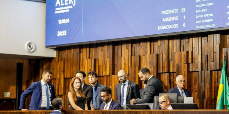 Deputados se reúnem na Alerj nesta quinta-feira, mas não discute a prisão do presidente Rodrigo Bacellar; de gravata vermelha e óculos, o presidente interino, Guilherme Delaroli, e outros deputados ouvem as críticas do deputado Flávio Serafini à Casa — Foto: Gabriel de Paiva
