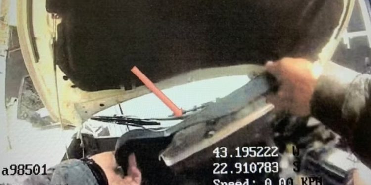 Imagem da câmera corporal mostra sargento do Batalhão de Choque retirando a tampa do motor de um carro — Foto: Reprodução/ Fantástico, TV Globo