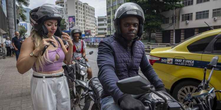 Mesmo após incidente na Avenida Brasil, a autônoma Denise Fernandes continua fazendo seus trajetos de moto — Foto: Guito Moreto