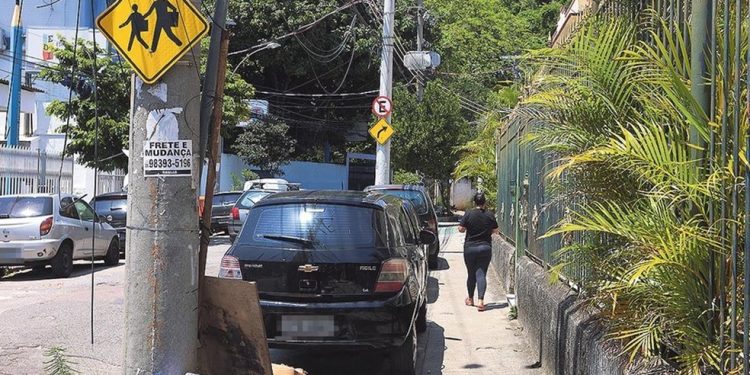 Nas barbas da fiscalização. Carros param na calçada da rua no Andaraí onde fica o depósito dos veículos rebocados — Foto: Fabiano Rocha
