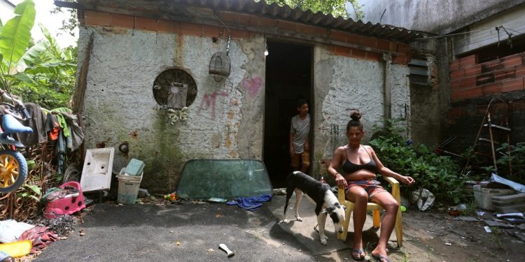 Sharlene da Silva Frazão e seu filho Alyson: a casa da família, em Caxias, foi alagada nas últimas chuvas — Foto: Fabiano Rocha