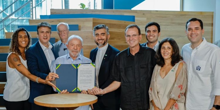 O presidente Lula, o ministro da Educação Camilo Santana e o reitor da PUC-Rio padre Anderson Antonio Pedroso celebram a assinatura da habilitação do curso de medicina da universidade da Gávea — Foto: Alan Costa / SME