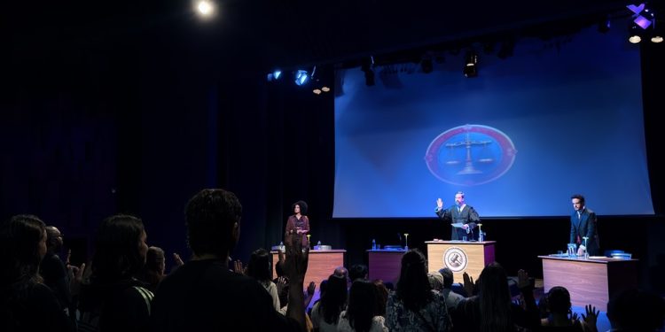 No palco estão juiz, promotor, advogado de defesa, réu e vítima; público faz juramento — Foto: Divulgação/Patrick Sampaio