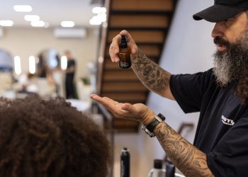 Will Anselmo aplica Dark Oil Sebastian na preparação da modelo para o desfile — Foto: Marco Sobral