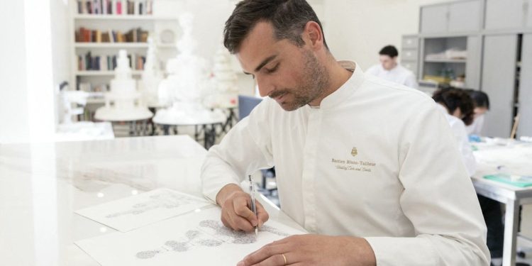 O chef confeiteiro francês Bastien Blanc-Tailleur faz o design de um bolo de casamento em seu estúdio em Saint-Remy-les-Chevreuse, no sudoeste de Paris — Foto: Thomas Samson / AFP