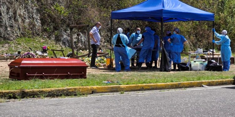 Peritos forenses exumam o corpo do preso político Víctor Quero Navas no cemitério Parque Jardín La Puerta, em Caracas, em 8 de maio de 2026 — Foto: AFP