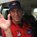 O alpinista britânico Kenton Cool acena de dentro de um carro ao chegar ao aeroporto de Katmandu — Foto: Prakash MATHEMA / AFP