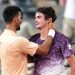 O brasileiro João Fonseca (à direita), cumprimenta o sérvio Novak Djokovic ao final da partida de simples masculina do sexto dia do torneio de tênis do Aberto da França, na quadra Philippe-Chatrier, no complexo de Roland-Garros — Foto: Dimitar DILKOFF / AFP